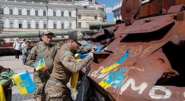 epa10773848 Ukrainian servicemen sign a National flag as they visit an exhibition of destroyed Russian military machinery on display in front of St. Mikhailovsky Cathedral in Kyiv, Ukraine, 28 July 2023 Russian troops entered Ukrainian territory on 24 February 2022, starting a conflict that has provoked destruction and a humanitarian crisis.  EPA/SERGEY DOLZHENKO