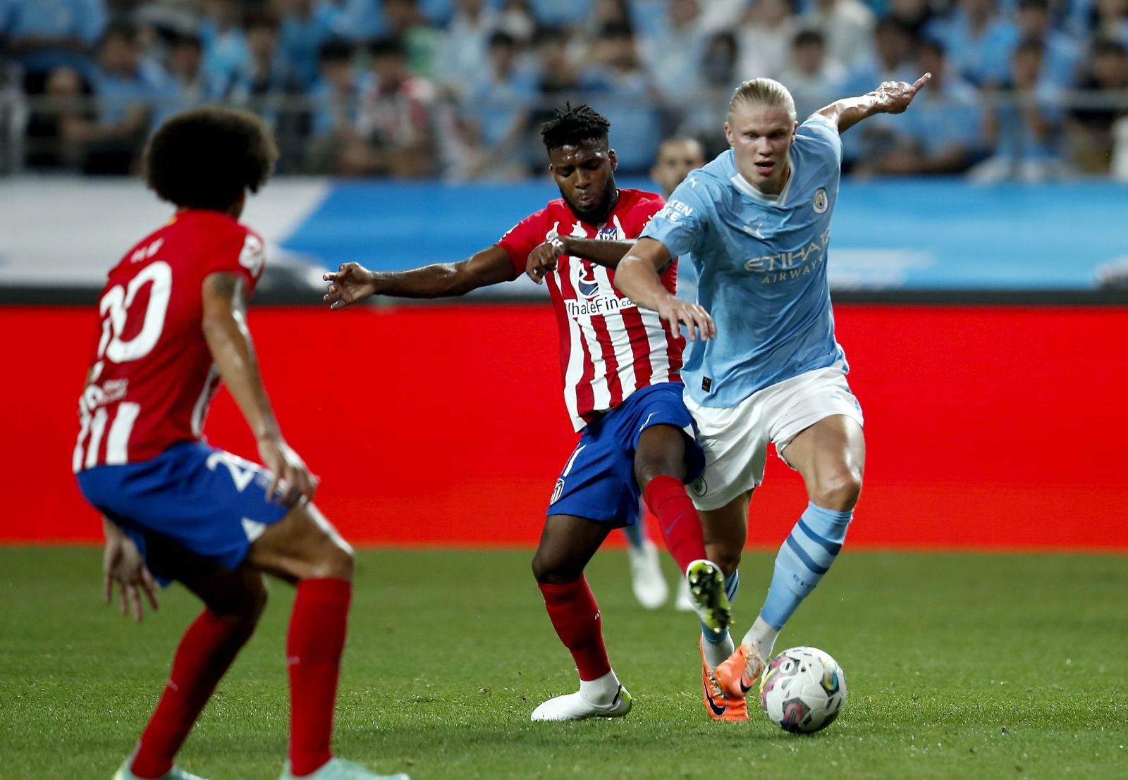epa10777183 Manchester City' Erling Haaland (R) in action against Atletico Madrid'sThomas Lemar (C) during a soccer pre season friendly match between Manchester City vs Atletico Madrid at Sangam World Cup Stadium in Seoul, South Korea, 30 July 2023.  EPA/JEON HEON-KYUN