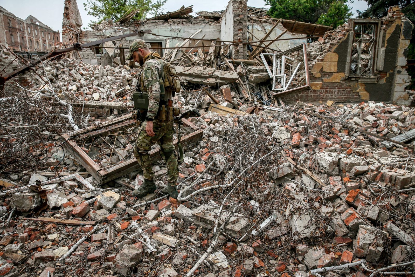epa10758513 A Ukrainian serviceman of the 24 separate mechanized brigade named after King Danylo, walks amid the ruins of a building destroyed by Russian missile strikes in the Donetsk region, Ukraine, 20 July 2023. The war in Ukraine, which started when Russia entered the country in February 2022, marked in July its 500th day. According to the UN, since the conflict started, more than 9000 civilians have been killed and more than 6 million others are now refugees worldwide.  EPA/OLEG PETRASYUK