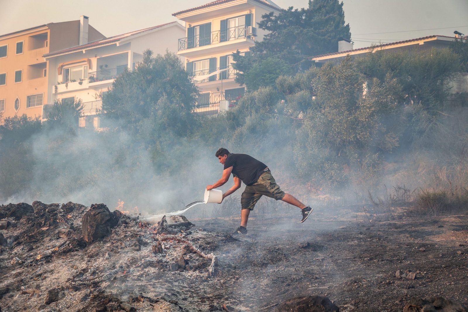 epa10768498 A man battles the flames in Alto do Alvide, Cascais, Portugal, 25 July 2023. 423 operatives, supported by 111 vehicles and 14 aerial means, are fighting a fire that broke out in Alcabideche, in the municipality of Cascais, near Lisbon.  EPA/MANUEL DE ALMEIDA