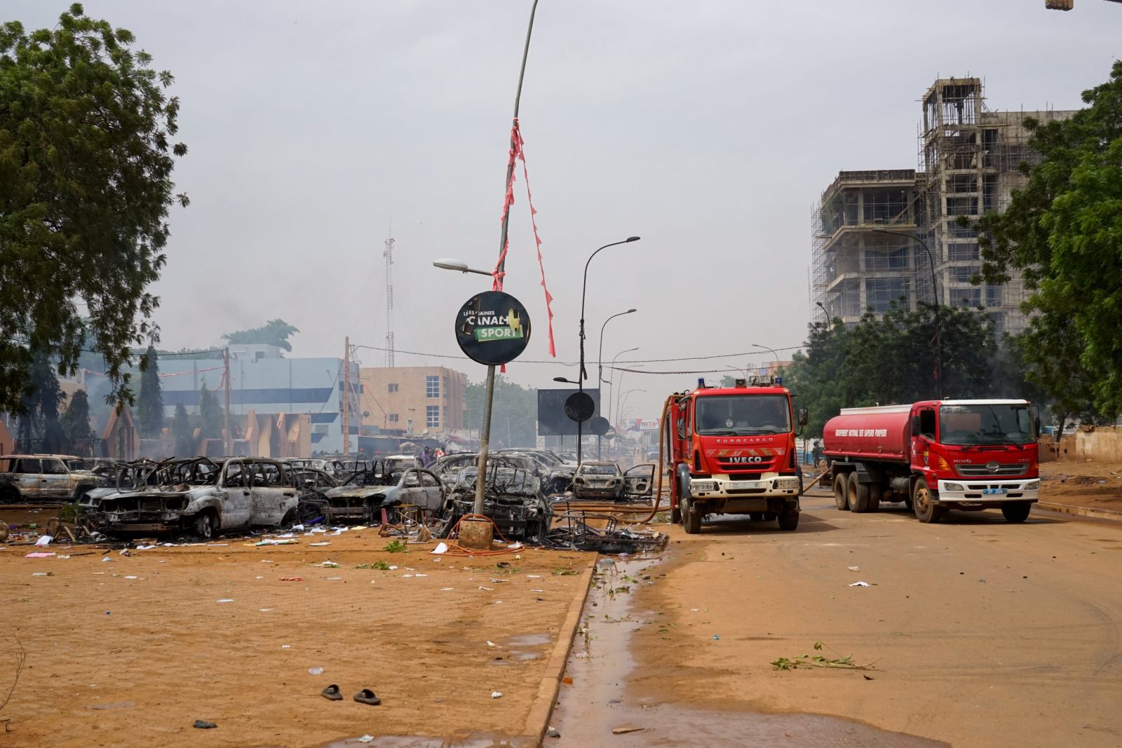 epa10771854 Firefighter trucks next to torched cars at a parking lot near the Nigerien Party for Democracy and Socialism headquarters in Niamey, Niger, 27 July 2023. Mutinous soldiers calling themselves the National Council for the Safeguarding of the Country claimed to have overthrown President Mohamed Bazoum, Niger's democratically elected President, in a Televised address on 26 July evening.  EPA/STR