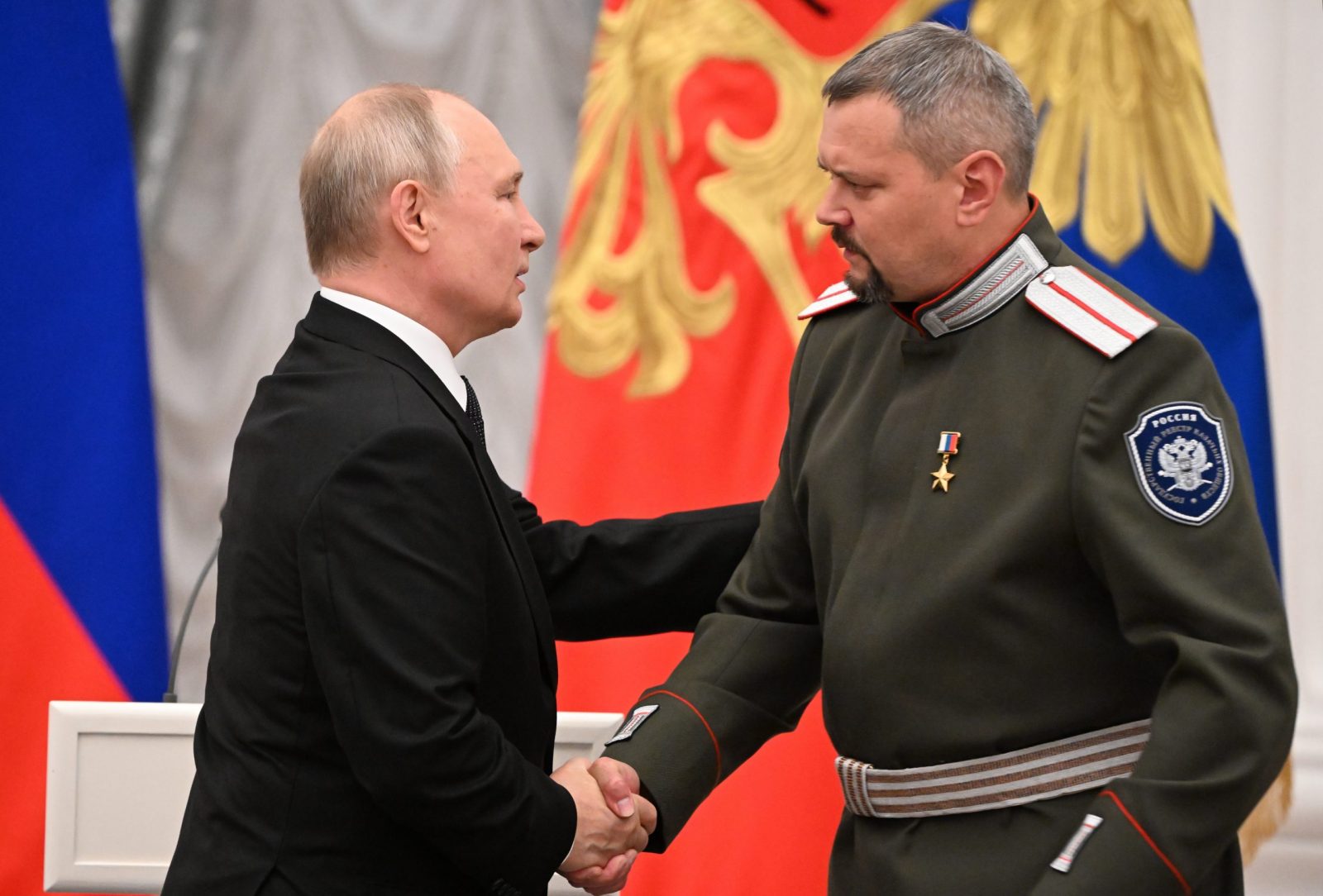epa10781568 Russian President Vladimir Putin (L) shakes hands with commander of the volunteer Cossack expeditionary battalion 'Siberia' Oleg Likontsev, who is awarded the title of Hero of the Russian Federation during  the ceremony of presenting the highest state awards of the Russian Federation in Moscow, Russia, 02 August 2023.  EPA/ALEXEY MAISHEV / KREMLIN / POOL