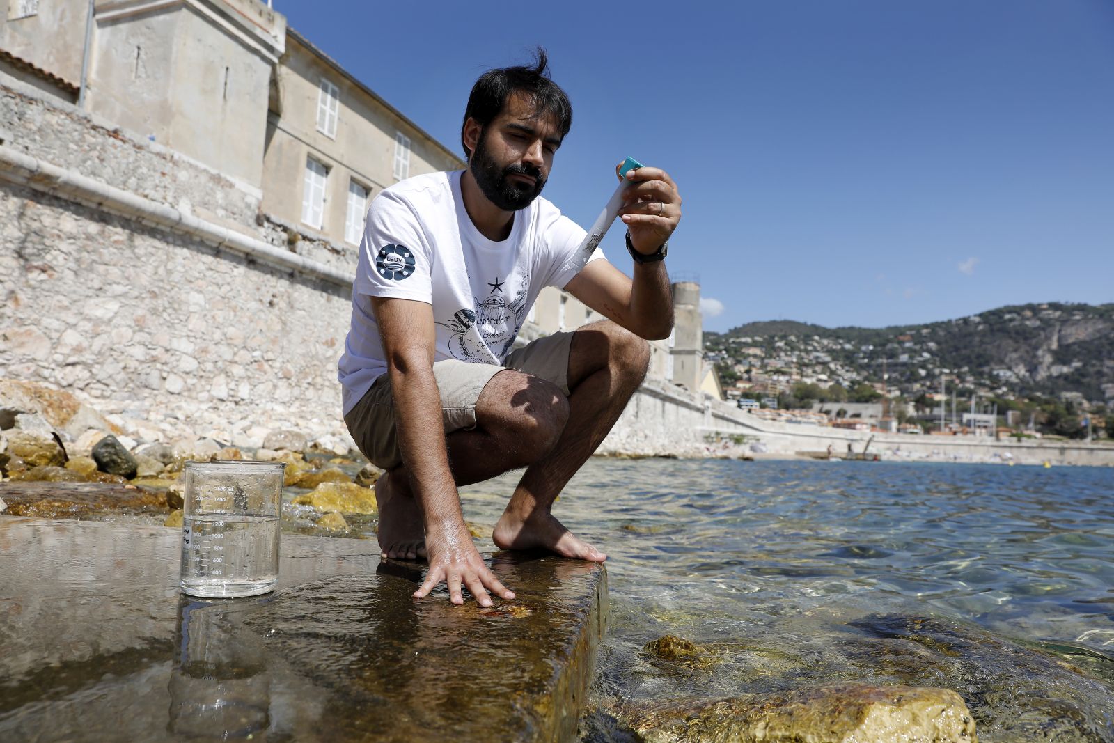 epa10784284 Joao Carvalho of the Sorbonne Institute measures the temperature of the Mediterranean Sea waters in Villefranche-sur-Mer, France, 04 August 2023. The water temperature of the Mediterranean Sea has reached a record high of up to 28.5 degrees Celcius in some places along the French Riviera coast.  EPA/SEBASTIEN NOGIER