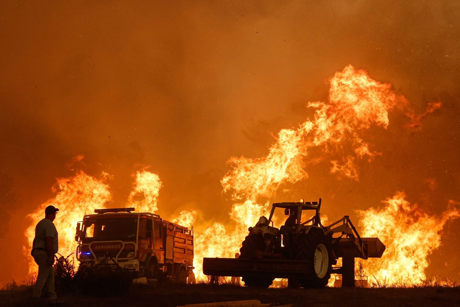 epa10789282 A man watches the fire in the municipality of Odemira, 07 August 2023.  The fire, which broke out in the Baiona area, in the parish of São Teotónio, 05 August, has already forced the evacuation of four locations in the municipality of Odemira (Vale dos Alhos, Vale de Água, Choça dos Vales and Relva Grande) and a rural tourism unit.  EPA/LUIS FORRA