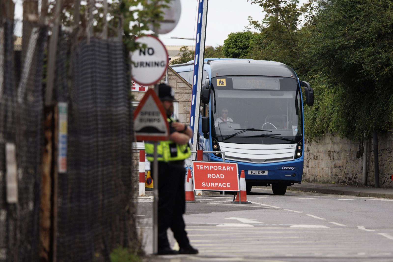 epaselect epa10790318 A bus departs the Portland Port in Dorset, Britain, 08 August 2023. The Bibby Stockholm barge started to receive asylum seekers despite safety concerns and claims of inhumane conditions, amid the British government’s efforts to reduce the use of commercial hotels to temporarily house approximately 50,000 asylum seekers arriving in Britain whilst their claims are assessed by the Home Office.  EPA/TOLGA AKMEN