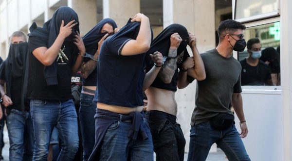 epa10791713 Hooligans, who were arrested after violent clashes between AEK and Dinamo Zagreb supporters in Athens, are transferred by police officers to appear before a public prosecutor, in Athens, Greece, 09 August 2023. Ninety four individuals, mostly Croatian nationals who were arrested during clashes between Greek and Croatian football fans in Athens on 07 August, will be presented before a prosecuting magistrate, while DNA samples are collected from all in order to identify the murderer of a 29-year-old AEK fan, who died during the clashes.  EPA/GEORGE VITSARAS