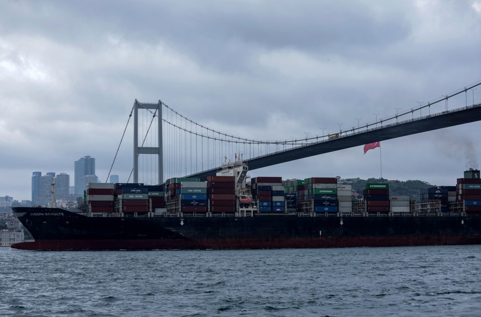 epa10805159 The Hong Kong-flagged Joseph Schulte, the first cargo ship to leave Ukraine's Odesa port since the end of the grain deal despite Russian threats, sails under the 15 July Martyrs Bridge on the Bosphorus in Istanbul, Turkey, 18 August 2023.  EPA/ERDEM SAHIN