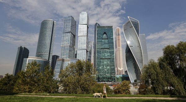 epa10805245 A woman walks a dog in front of the Moscow-City business center and Expocentre exhibition center, where a drone reportedly fell in Moscow, Russia, 18 August 2023. According to the Russian Ministry of Defense, air defense systems on 18 August shot a drone causing a change of its flight trajectory before falling on a non-residential building near Krasnopresnenskaya Embankment in Moscow. The Russian Defense Ministry blamed Ukraine for the attack that left no casualties. Moscow Mayor Sergei Sobyanin said the drone fell in the Expocentre zone and no significant damage was caused to the building.  EPA/SERGEI ILNITSKY