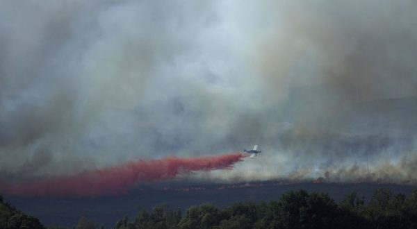 epa10805986 An aircraft takes part in extinction works of a forest fire originated in Palas de Rei, Lugo, northern Spain, 18 August 2023. The fire has already burnt around 20 hectares and over 40 assets have been deployed in the area.  EPA/Eliseo Trigo