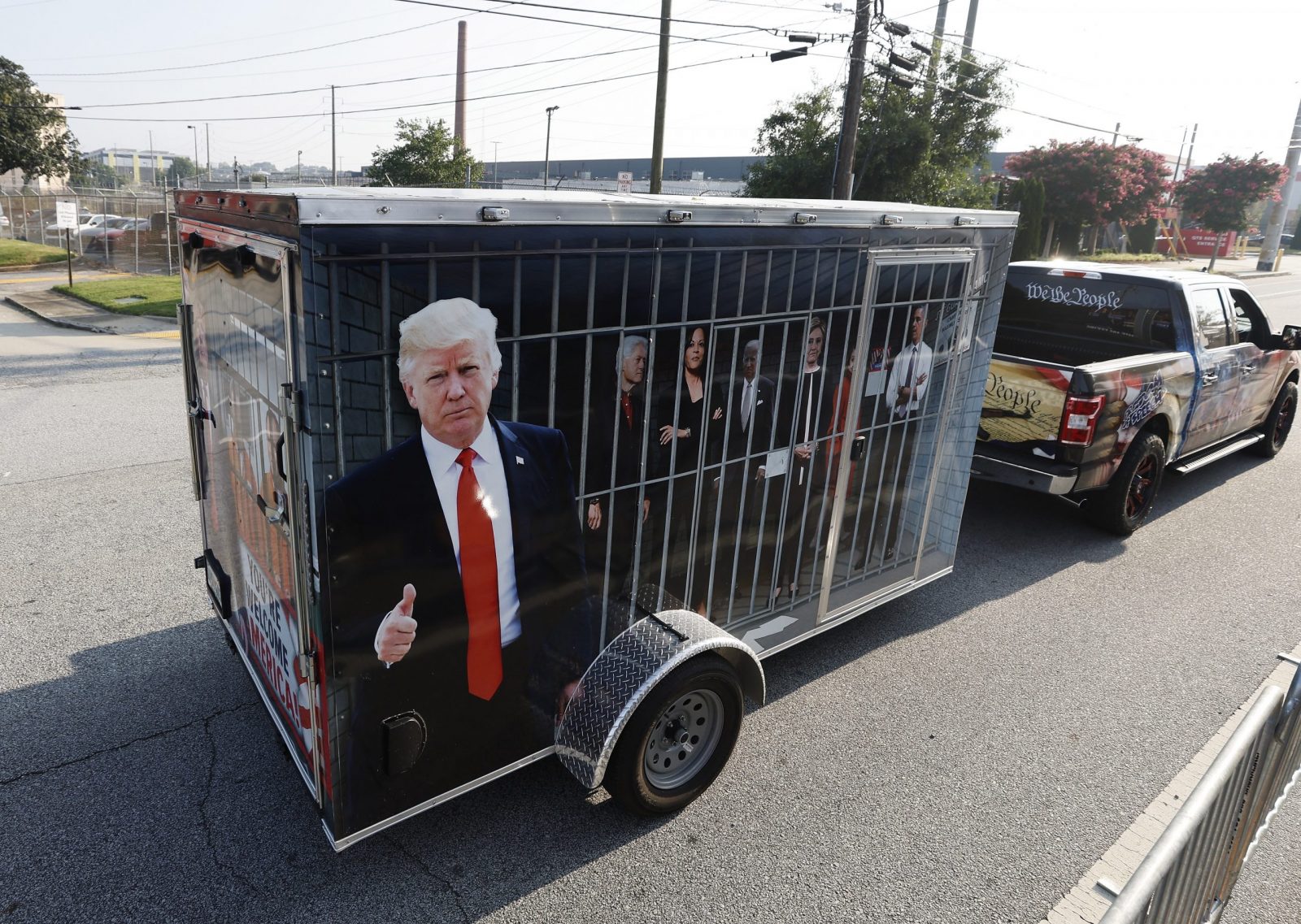epa10817577 A supporter of former US President Donald Trump tows a makeshift jail cell containing depictions of Democratic leaders, outside the entrance of the Fulton County Jail, prior to the arrival of Trump to turn himself into authorities after a grand jury indictment against him and 18 co-defendants for 2020 election interference in Atlanta, Georgia, USA, 24 August 2023.  EPA/ERIK S. LESSER