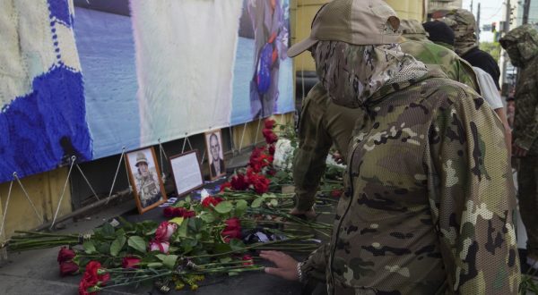epa10817917 Men dressed in a military uniform brings flowers to an informal memorial with pictures of PMC Wagner chief  Yevgeny Prigozhin and PMC Wagner commander Dmitry Utkin in downtown of Rostov-on Don, Russia, 24 August 2023. An investigation was launched into the crash of an aircraft in the Tver region in Russia on 23 August 2023, the Russian Federal Air Transport Agency said in a statement. Among the passengers was Wagner chief Yevgeny Prigozhin, the agency reported.  EPA/STRINGER