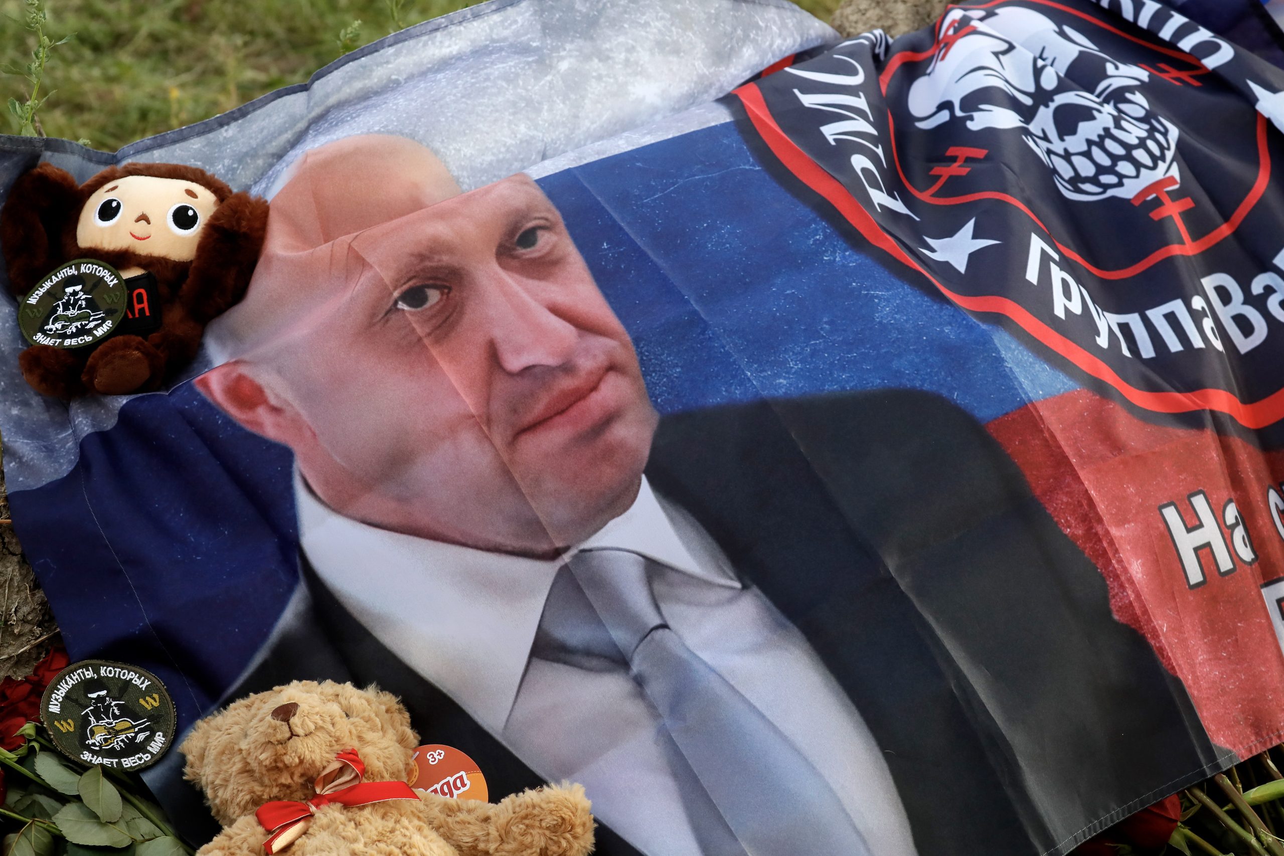 epa10820022 A flag with the image of Yevgeny Prigozhin and the emblem of the Wagner Group (PMC Wagner) is seen at an informal memorial held next to the former 'PMC Wagner Centre' in St. Petersburg, Russia, 25 August 2023. An investigation was launched into the crash of an aircraft in the Tver region in Russia on 23 August 2023, the Russian Federal Air Transport Agency said in a statement. Among the passengers was Wagner chief Yevgeny Prigozhin, the agency reported.  EPA/ANATOLY MALTSEV