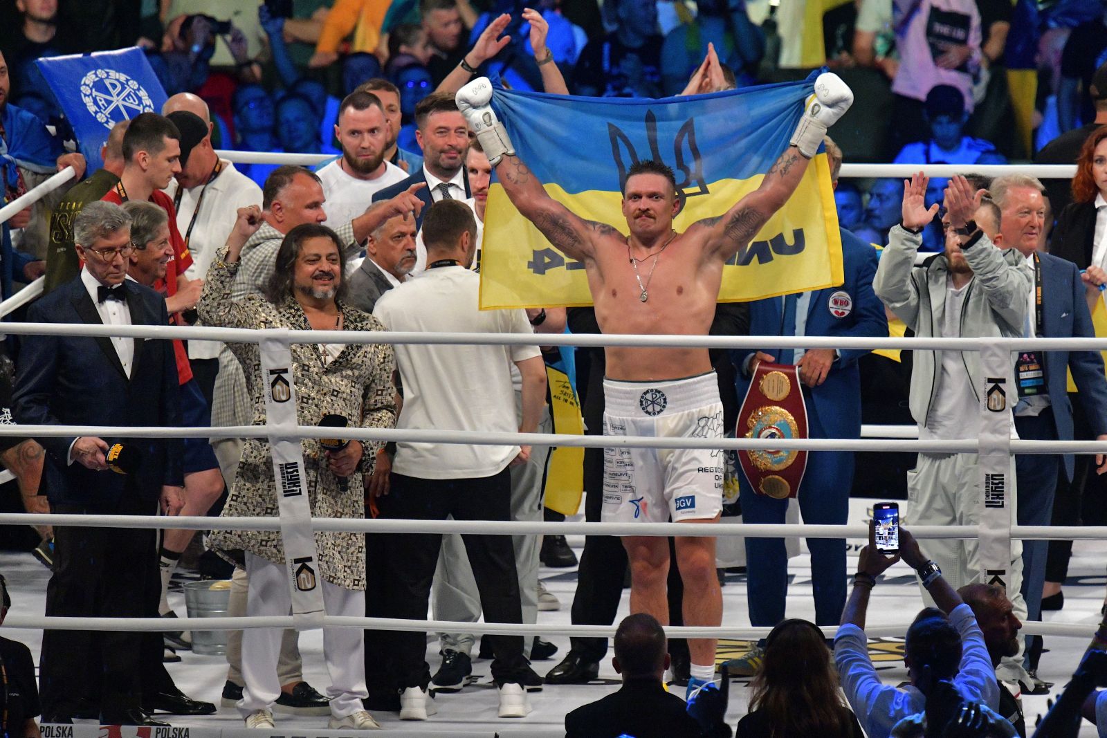 epa10822574 Oleksandr Usyk (C) of Ukraine celebrates his victory over Daniel Dubois of Great Britain after their heavyweight world title fight of four boxing federations; WBO, IBF, WBA, and IBO in Wroclaw, Poland, 26 August 2023.  EPA/Sebastian Borowski POLAND OUT