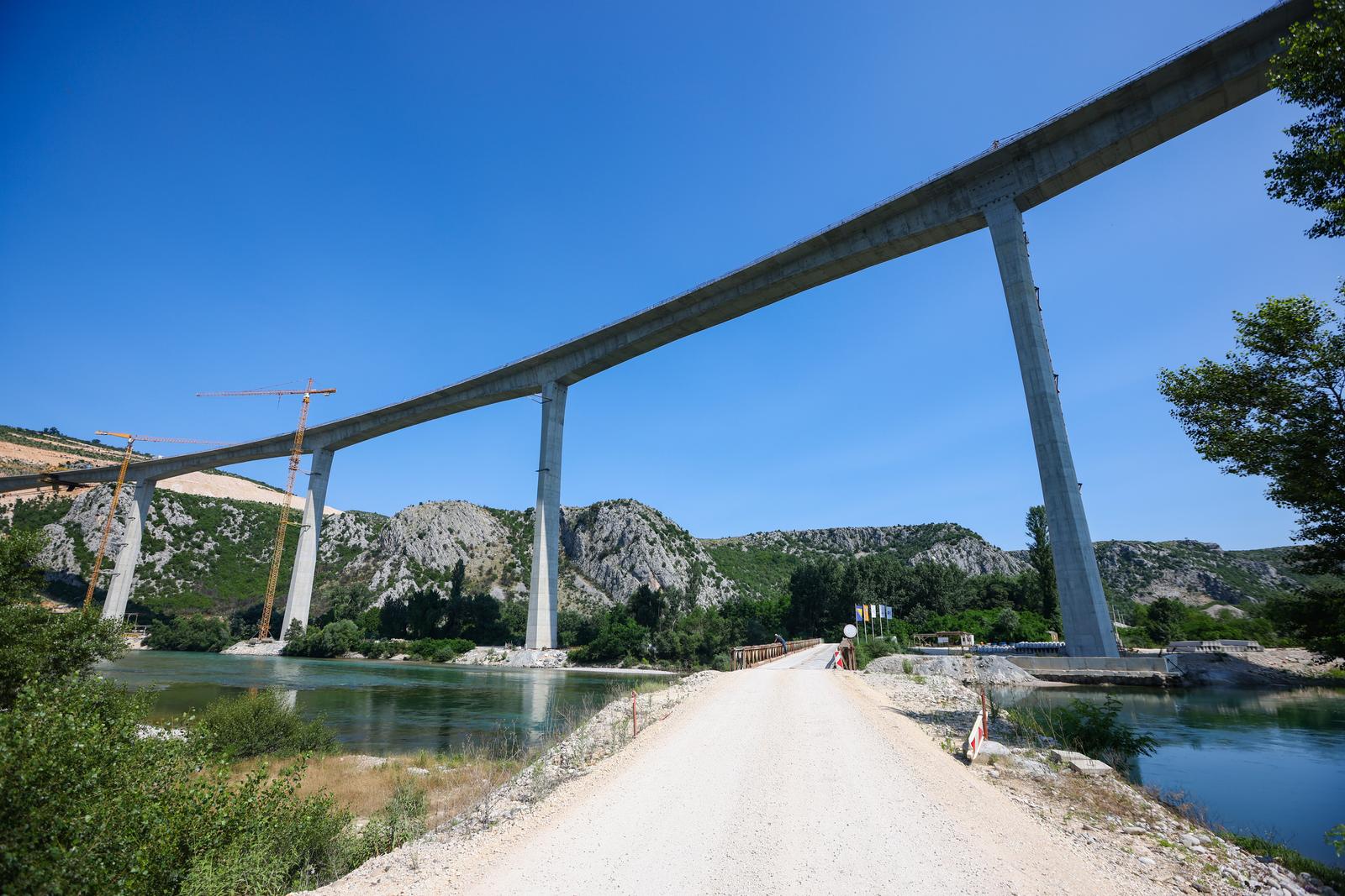 18.06.2023.,Capljina -  Jedan od najvisih mostova u regiji, most Pocitelj uskoro ce biti  spojen s lijevom obalom Neretve. Most Pocitelj visok je nesto vise od stotinu metara, dok njegova duzina iznosi 918 metara. Most ce imati dva vozna traka u svakom smjeru, te je projektiran za brzinu do 130 kilometara na sat. Specificnost ovog mosta je da se citava sirina raspona nalazi na jednostrukom nizu stupova, tj, kolnici nisu fizicki odvojeni. Most Pocitelj najveci je objekt na koridoru Vc. 


 Photo: Denis Kapetanovic/PIXSELL
