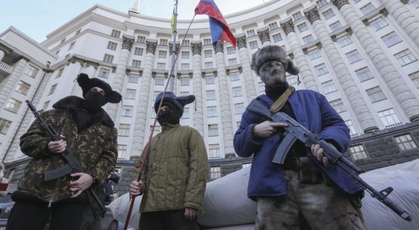 epa05162288 Ukrainian activists dressed like armed pro-Russian rebels perform during their rally in in front of the Government building in Kiev, Ukraine, 15 February 2015. The protesters demanded that all Russian businesses are banned in Ukraine. Relations between Russia and Ukraine are still tense after Ukraine ousted its pro-Russian president during mass protests 2014, calling for closer ties with the West. Russia subsequently occupied and annexed Ukraine's southern Crimea region and supported a pro-Russian separatist rebellion in Ukraine's two eastern-most regions.  EPA/VOLODYMYR PETROV