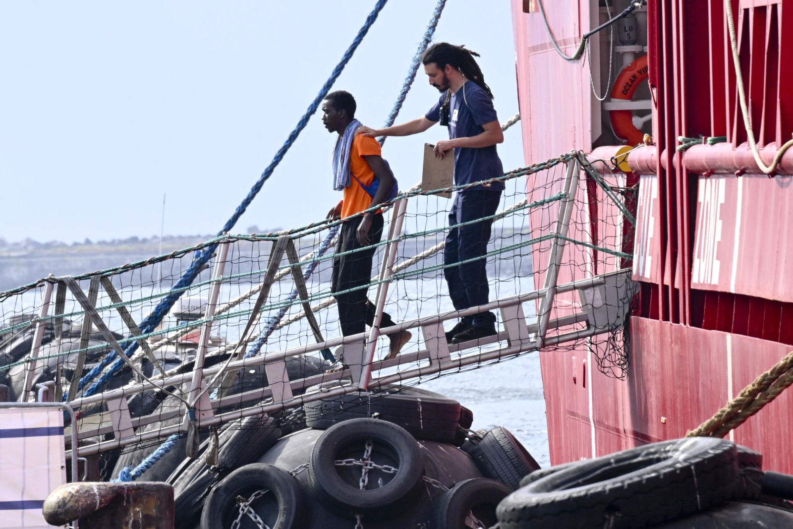 epa10824956 A migrant disembarks from the 'Ocean Viking', the SOS Mediterranee ship that rescued 439 migrants between Lampedusa and Tunisia, after arriving in the port of Naples, Italy, 28 August 2023.  EPA/CIRO FUSCO