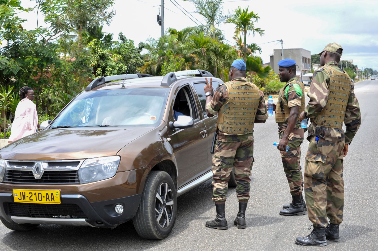 epa10828741 Members of the security forces gesture to a driver, at a checkpoint in the streets of Akanda, Gabon, 30 August 2023. Members of the Gabonese army on 30 August announced on national television that they were canceling the election results and putting an end to Gabonese President Ali Bongo's regime, who had been declared the winner.  EPA/STR
