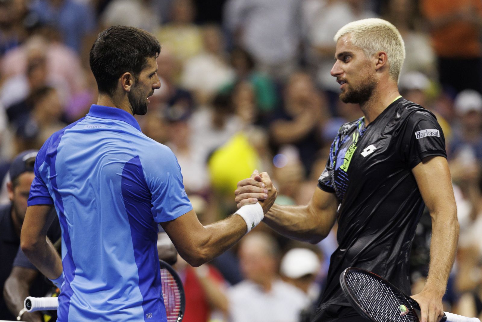 epa10839048 Novak Djokovic of Serbia (L) greets Borna Gojo of Croatia (R) at the net after Djokovic defeated Gojo in their fourth round match at the US Open Tennis Championships at the USTA National Tennis Center in Flushing Meadows, New York, USA, 03 September 2023. The US Open runs from 28 August through 10 September.  EPA/CJ GUNTHER