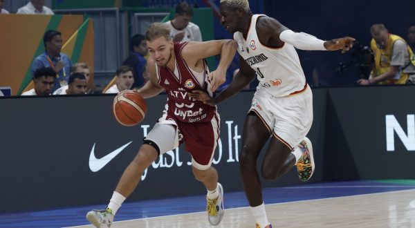 epa10843395 Arturs Zagars of Latvia (L) in action against Isaac Bonga of Germany (R) during the FIBA Basketball World Cup 2023 quarter final match between Germany and Latvia in Manila, Philippines, 06 September 2023.  EPA/ROLEX DELA PENA
