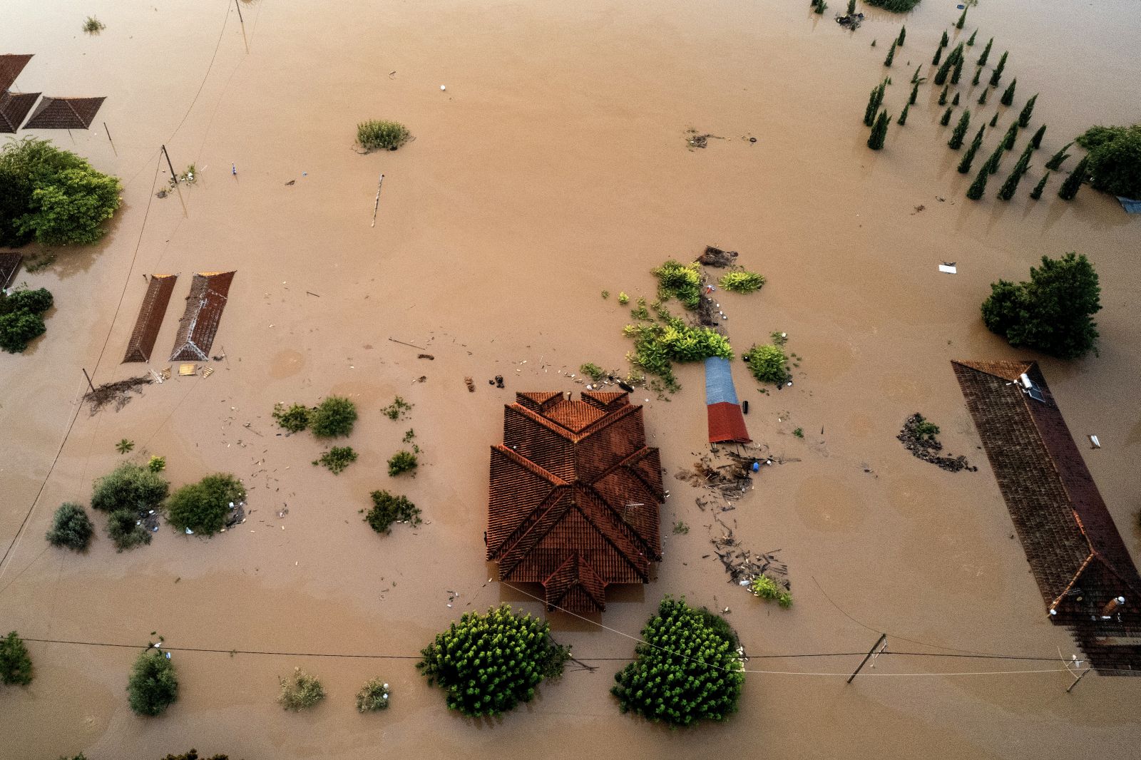epa10847870 A drone view shows submerged buildings in a flooded area at sunrise, in Piniada village, near Trikala, Thessaly region, after storm 'Daniel' swept across central Greece, 08 September 2023. At least six people died and another six are still missing in the flooded central Greek region as unprecedented bad weather conditions struck the country. Most villages and the capitals of the regional units of Karditsa and Trikala are facing serious problems as a result of the heavy rains hitting the country. Homes, livestock units and businesses have been affected with incalculable damages, while residents, in some areas, are trapped in their houses, due to the height of the water.  EPA/ACHILLEAS CHIRAS