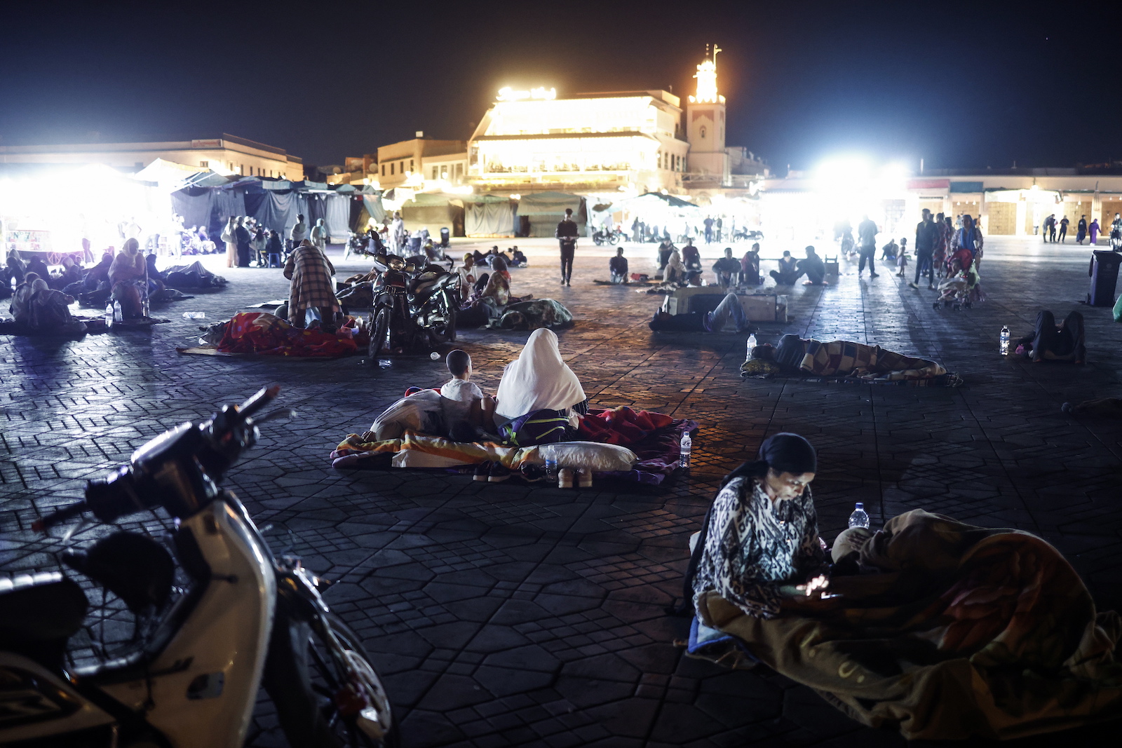 epa10851792 Hundreds of people sleep outside on Jeema El Fna square after a powerful earthquake hit Morocco, in Marrakech, Morocco, early 10 September 2023. A powerful earthquake that hit central Morocco late 08 September, killed 1,037 people and injured more than 1,200 others, the country's Interior Ministry announced on 09 September cited by public television. The earthquake, measuring magnitude 6.8 according to the USGS, damaged buildings from villages and towns in the Atlas Mountains to Marrakesh.  EPA/YOAN VALAT