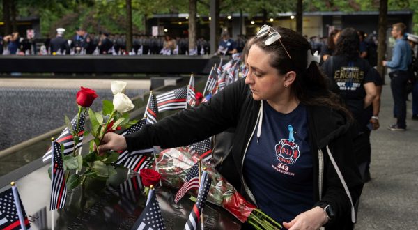epa10854767 Clare Baron lays a rose for her cousin Mark Whitford at the National September 11 Memorial during an annual ceremony to commemorate the 22nd anniversary of the September 11, 2001 terrorist attacks in New York, New York, USA, 11 September 2023.  The USA is commemorating the 22nd anniversary of the terrorist attack of 11 September 2001, when terrorists flew hijacked planes into the World Trade Center, the Pentagon, and crashed a plane in Shanksville, Pennsylvania.  EPA/ADAM GRAY