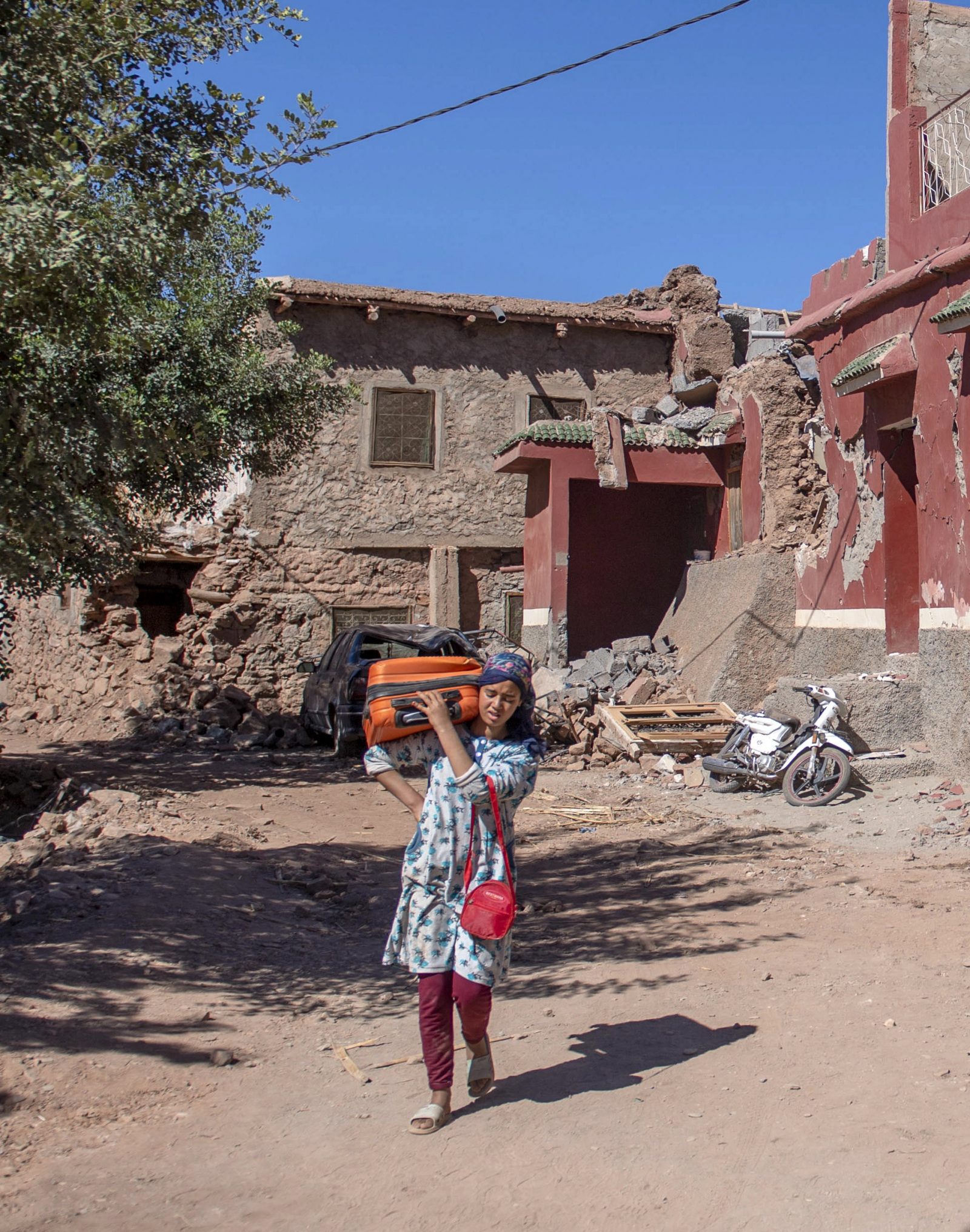 epa10863871 A girl walks among the rubble of damaged buildings at the earthquake-affected village of Tinmel, south of Marrakesh, Morocco, 16 September 2023. The 6.8-magnitude earthquake struck central Morocco late September 08, killing nearly 3,000 people and damaging buildings from villages and towns in the Atlas Mountains to Marrakesh, according to a report issued by the country's Ministry of Interior.  EPA/JALAL MORCHIDI