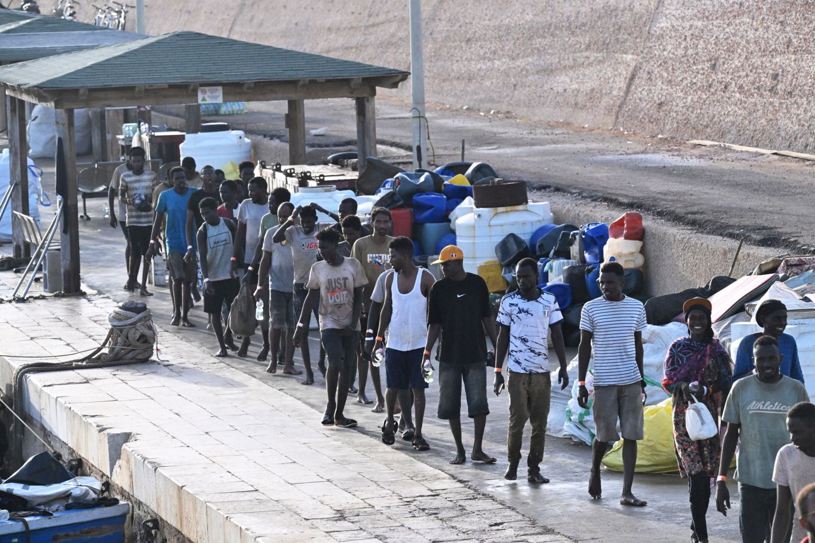 epa10867466 Migrants arrive at 'Molo Favarolo' in Lampedusa, southern Italy, 18 September 2023. Migrants traveling on a small boat were rescued by the Coast Guard. The group, after the health triage, will be transferred to the hotspot where, at the moment, there are 1,104 people.  Italian Deputy Premier and Foreign Minister Antonio Tajani on 15 September called for the intervention of the United Nations in response to the significant increase in the arrival of migrants and refugees by sea to Italy in recent days.  EPA/CIRO FUSCO