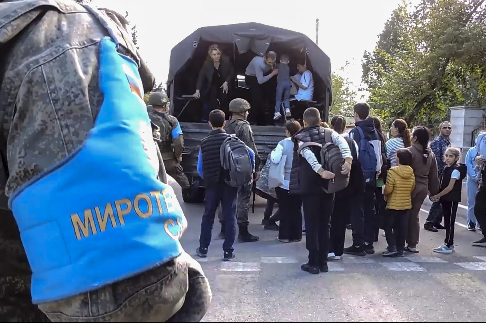 epa10871129 A still image taken from a handout video provided by the Russian Defence Ministry press-service shows Russian peacekeepers evacuating Nagorno-Karabakh civilians at an undisclosed location, 20 September 2023. More than two thousand civilians, including 1,049 children, were evacuated from the 'most dangerous areas' of Nagorno-Karabakh, the Russian ministry said, adding that since 12:00 pm on 19 September 2023, the Russian peacekeeping contingent recorded 'numerous facts of ceasefire violations on the Azerbaijani side along the entire line of contact'. Azerbaijan's Ministry of Defense announced on 19 September the launching of local 'anti-terrorism' measures against the Armenian military in the disputed Nagorno-Karabakh region in order to restore the constitutional order of Azerbaijan.  EPA/RUSSIAN DEFENCE MINISTRY PRESS SERVICE HANDOUT -- MANDATORY CREDIT -- BEST QUALITY AVAILABLE -- HANDOUT EDITORIAL USE ONLY/NO SALES