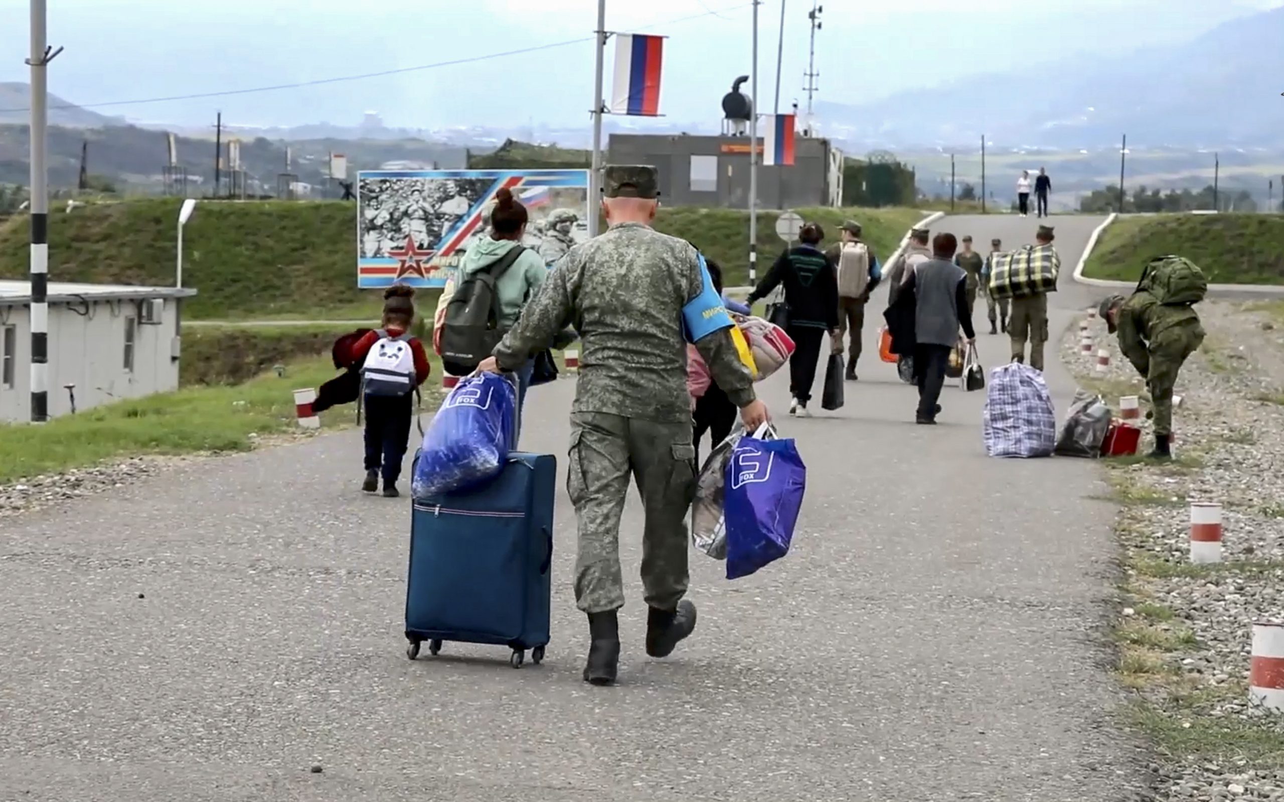 epa10874835 A still image taken from a handout video provided by the Russian Defence Ministry press-service shows civilians at the Russian peacekeepers' camp near Stepanakert, Nagorno-Karabakh, 21 September 2023. About 5,000 people have been brought to the location of the Russian peacekeeping contingent as Russian peacekeepers have evacuated civilians from Martakert, Martuni, and Askeran districts of Nagorno-Karabakh, the Russian Defence Ministry announced on 21 September. Azerbaijan government's announced that a ceasefire was agreed with Armenian separatists in Nagorno-Karabakh on 20 September, after a 24-hour military offensive to take control of the enclave.  EPA/RUSSIAN DEFENCE MINISTRY PRESS SERVICE HANDOUT MANDATORY CREDIT -- BEST QUALITY AVAILABLE HANDOUT EDITORIAL USE ONLY/NO SALES