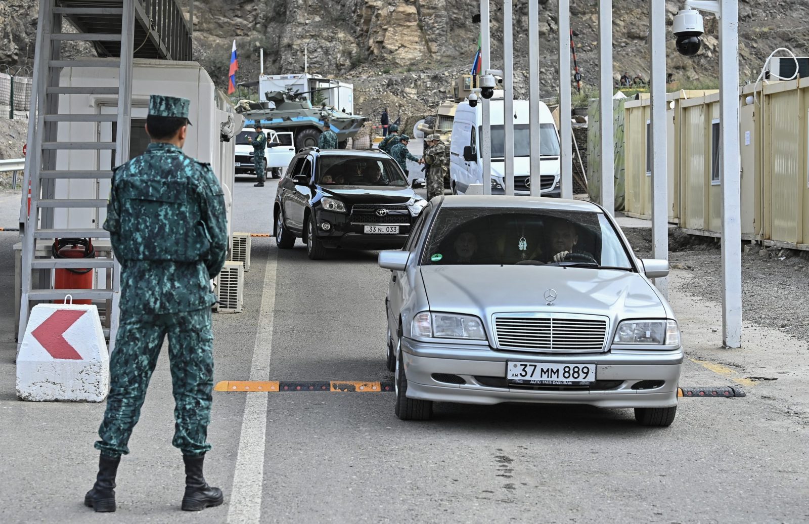 epa10882044 Azeri servicemen stand guard as ethnic Armenians leave Nagorno-Karabakh through a checkpoint on the entrance of the Lachinsky corridor, which connects the Nagorno-Karabakh region with Armenia, in Lachin, Azerbaijan, 25 September 2023. Azerbaijan on 19 September 2023 launched a brief military offensive on the contested region of Nagorno-Karabakh, a breakaway enclave that is home to some 120,000 ethnic Armenians. The Armenian government announced the evacuation of about 3,000 local residents from the region following the ceasefire agreed on 20 September 2023, as Azerbaijan opened all checkpoints with Armenia for the unimpeded exit of civilians from the territory of Nagorno-Karabakh. Russian peacekeepers escorted convoys of civilians from Nagorno-Karabakh leaving for Armenia, the Russian Ministry of Defense reported.  EPA/ROMAN ISMAYILOV