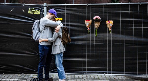 epa10889049 People react next to flowers left at the building on Heiman Dullaertplein in Rotterdam, The Netherlands, 29 September 2023, where a 32-year-old man shot a 39-year-old woman and her 14-year-old daughter on 28 September. The perpetrator shot a 43-year-old man in a classroom of the Erasmus Medical Center. The three victims have died.  The suspect is in Police custody.  EPA/JEFFREY GROENEWEG