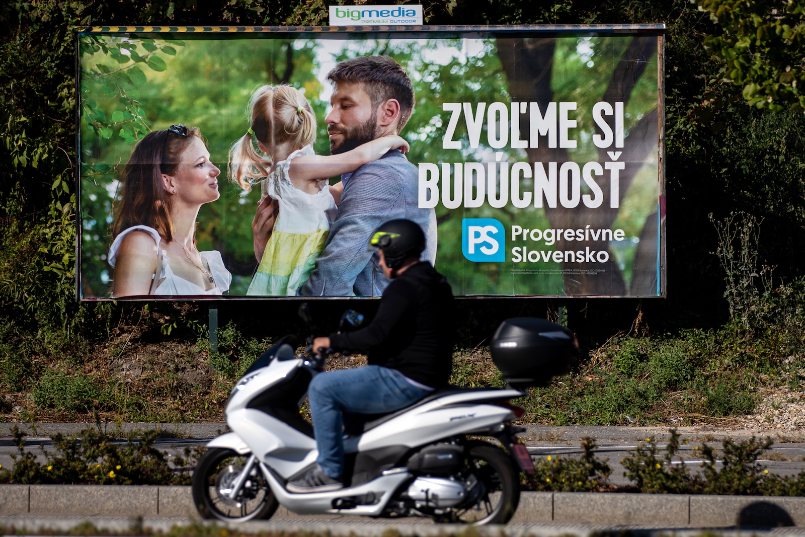 epa10890160 A man rides a scooter past an election poster of leader of Progresivne Slovensko party (Progressive Slovakia) Michal Simecka with a slogan that reads 'Let's choose the future', in Bratislava, Slovakia, 29 September 2023. Slovakia will be holding parliamentary elections on 30 September 2023.  EPA/MARTIN DIVISEK