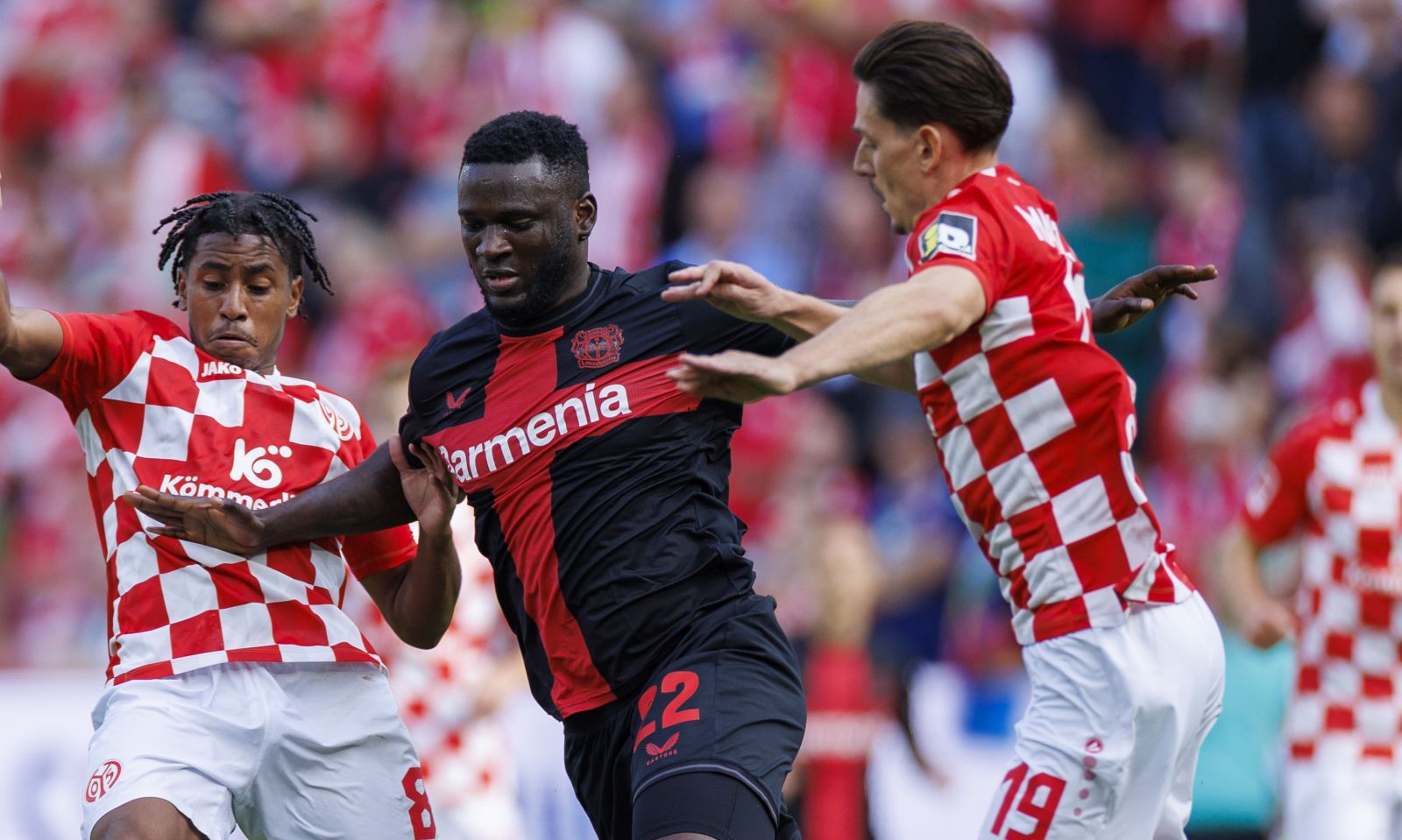 epa10891886 Leverkusen's Victor Boniface (C) in action against Mainz’s Leandro Barreiro (L) and Anthony Caci (R) during the German Bundesliga soccer match between 1. FSV Mainz 05 and Bayer 04 Leverkusen in Mainz, Germany, 30 September 2023.  EPA/CHRISTOPHER NEUNDORF CONDITIONS - ATTENTION: The DFL regulations prohibit any use of photographs as image sequences and/or quasi-video.
