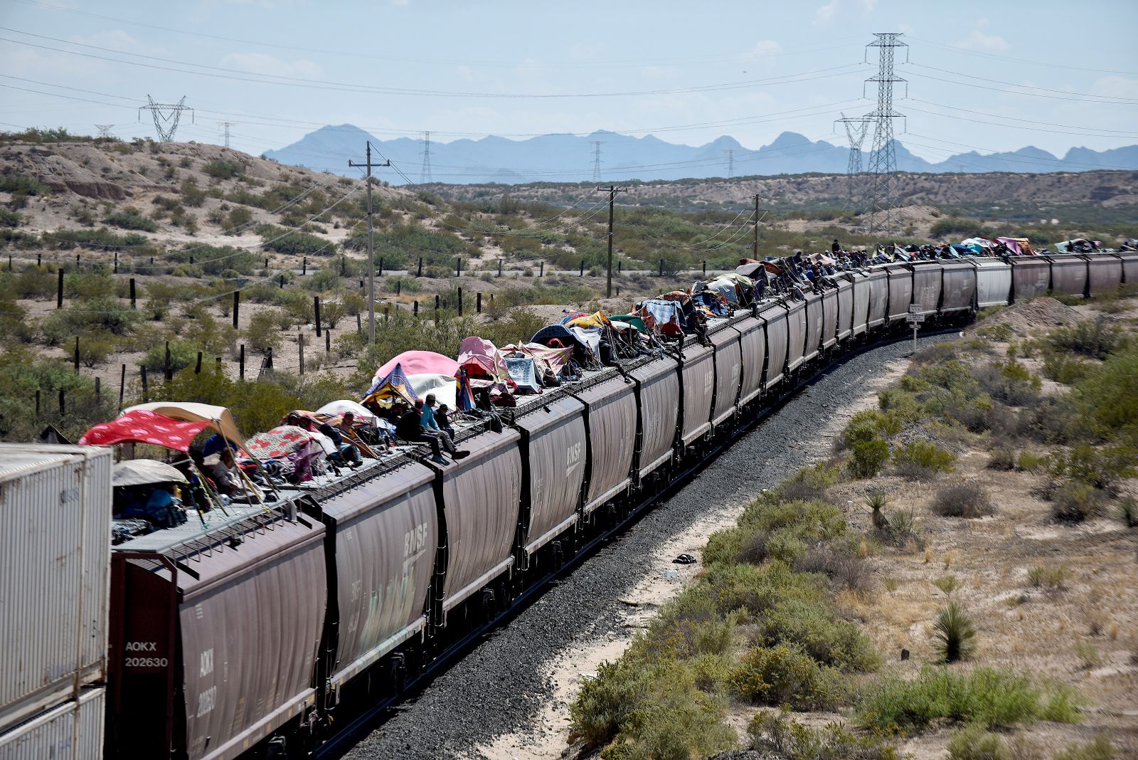 epa10898604 Migrants travel on the train known as 'the beast', near Juarez City, state of Chihuahua, Mexico, 03 October 2023. The head of the National Migration Institute (INM) of Mexico, Francisco Garduno, ruled out the possibility of thousands of migrants continuing to use a freight train that runs through the country to reach the US border.  EPA/Luis Torres