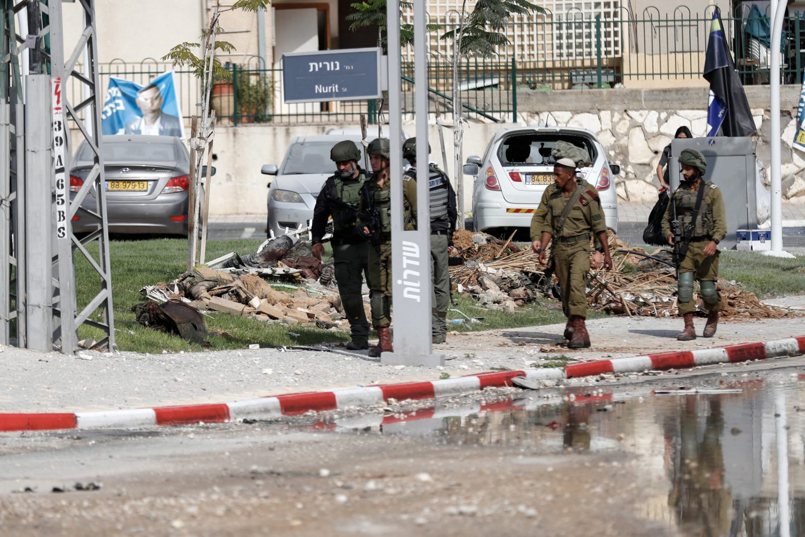 epa10907003 Israeli security forces walk past Hamas militants' dead bodies and debris outside the destroyed police station that was controlled by Hamas militants in the southern city of Sderot, close to the Gaza border, Israel, 08 October 2023. Rocket barrages were launched from the Gaza Strip as of early 07 October in a surprise attack claimed by the Islamist movement Hamas. More than 300 Israelis were killed and over 1,000 left injured in the attacks, the Israeli foreign ministry said.  EPA/ATEF SAFADI