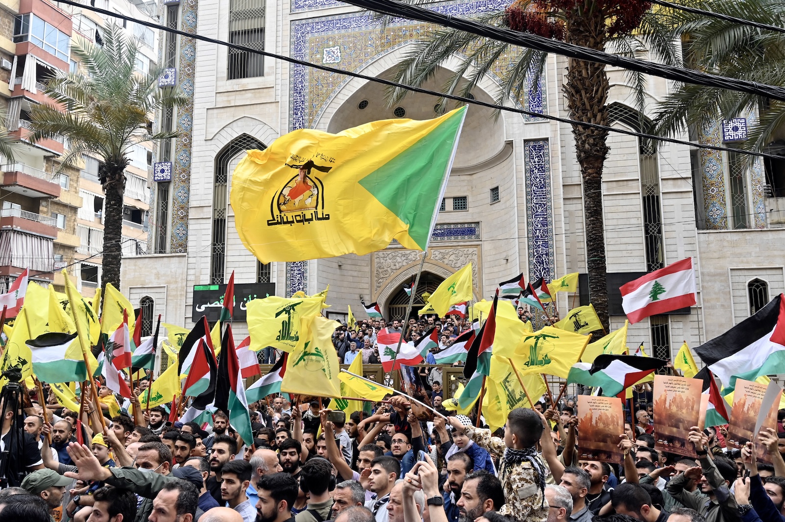 epa10907150 Supporters of Hezbollah wave Palestinian and Hezbollah flags during a rally to express solidarity with Palestinians in the Gaza Strip, in Beirut, Lebanon, 08 October 2023. Rocket barrages were launched from the Gaza Strip early 07 October in a surprise attack on Israel claimed by the Islamist movement Hamas.  EPA/WAEL HAMZEH
