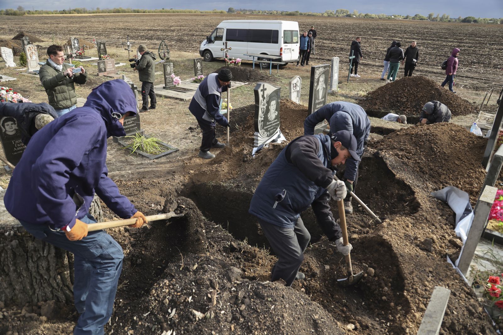 epa10909540 People dig a grave as relatives and friends of local resident Tetyana Kharbaka attend her funeral in the village of Hroza, Kupiansk district, Kharkiv region, Ukraine, 09 October 2023. Tetyana was one of the 52 people killed on 05 October when a Russian missile hit the village of Hroza as locals had gathered to mourn a fallen Ukrainian soldier.  EPA/YAKIV LIASHENKO 30792