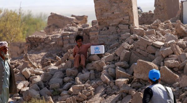 epa10911976 People affected by the earthquake sit on a rubble of damaged building in earthquake-hit  Zinda Jan district of Herat, Afghanistan, 10 October 2023. A 6.3-magnitude earthquake and the consecutive aftershocks that struck western Afghanistan during the weekend killed nearly 3,000, according to estimates by the government and nonprofit organizations. Over 2,000 people were wounded and 20 villages completely destroyed in the tremors.  EPA/SAMIULLAH POPAL