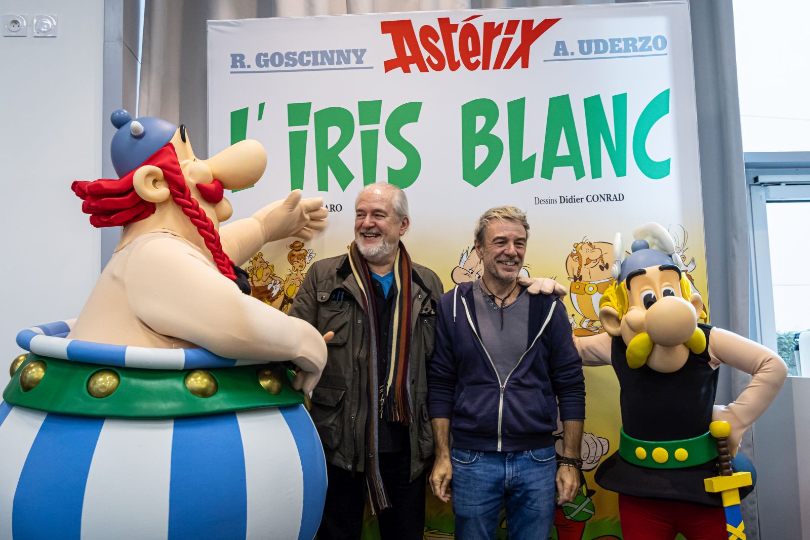 epa10921556 French screenwriter Fabrice Caro, aka Fabcaro (C-R) and French designer Didier Conrad (C-L) pose for photographs with Asterix and Obelix cartoon characters pose for photographs after a press conference for album 40 of Asterix and Obelix entitled 'L'Iris blanc' (the White Iris) in Vanves, near Paris, France, 16 October 2023. This album will be released on 26 October 2023.  EPA/CHRISTOPHE PETIT TESSON