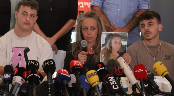 epa10923119 Keren Shelf, the mother of Israeli-French citizen Mia Shem, who is among some 200 people being held hostage by Hamas in Gaza, holds up a picture of her daughter during a press conference with family members in Tel Aviv, Israel, 17 October  2023. Hamas published a video October 16 showing Mia receiving medical treatment for a wound to her arm in captivity, claiming she was abducted from the site of a music festival where at least 260 people were killed.  EPA/ABIR SULTAN