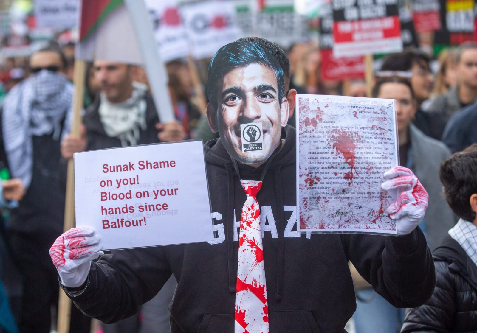 epa10944966 A protester wears a Britain's Prime Minister Rishi Sunak's face mask during a National March for Palestine organized by the Palestine Solidarity Campaign in London, Britain, 28 October 2023. Thousands of Israelis and Palestinians have died since the militant group Hamas launched an unprecedented attack on Israel from the Gaza Strip on 07 October, and the Israeli strikes on the Palestinian enclave which followed it.  EPA/TAYFUN SALCI
