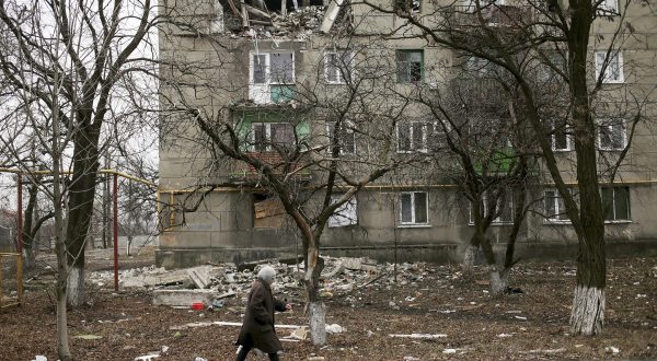 epa04642193 A local woman walks past a damaged with shelling building in Popasne village of Luhansk area, Ukraine, 28 February 2015. Ukraine is withdrawing heavy weapons from its front line in the east in order to test if a peace plan with separatist rebels can work, President Petro Poroshenko said 27 February 2015. The separatists say that they began the withdrawal days earlier. Both sides claim that observers from the Organization for Security and Co-operation (OSCE) are monitoring the withdrawal.  EPA/ANASTASIA VLASOVA