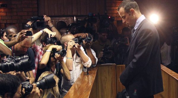 FILE - In this Friday, Feb 22, 2013 file photo photographers take photos of Olympic athlete Oscar Pistorius as he appears at a bail hearing for the shooting death of his girlfriend Reeva Steenkamp, in Pretoria, South Africa.  Pistorius could be granted parole on Friday, Nov. 24, 2023 after nearly 10 years in prison for killing his girlfriend. The double-amputee Olympic runner was convicted of a charge comparable to third-degree murder for shooting Reeva Steenkamp in his home in 2013. He has been in prison since late 2014. (AP Photo/Themba Hadebe, File)