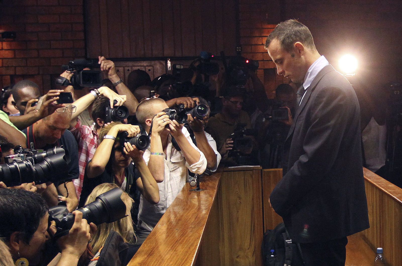 FILE - In this Friday, Feb 22, 2013 file photo photographers take photos of Olympic athlete Oscar Pistorius as he appears at a bail hearing for the shooting death of his girlfriend Reeva Steenkamp, in Pretoria, South Africa.  Pistorius could be granted parole on Friday, Nov. 24, 2023 after nearly 10 years in prison for killing his girlfriend. The double-amputee Olympic runner was convicted of a charge comparable to third-degree murder for shooting Reeva Steenkamp in his home in 2013. He has been in prison since late 2014. (AP Photo/Themba Hadebe, File)