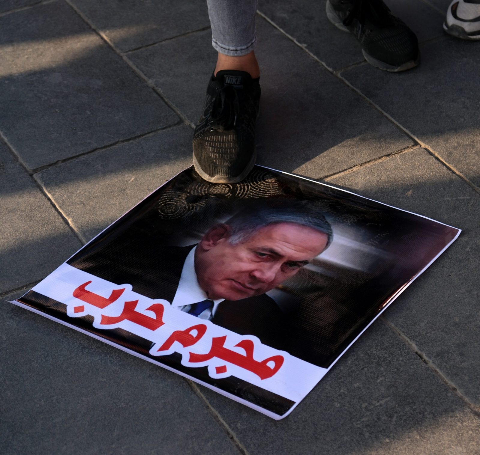 epa10943223 An Iraqi protester steps over a picture of Israel's Prime Minister Benjamin Netanyahu with a slogan reading in Arabic 'war criminal' during a pro-Palestinians rally, at Tahrir square in central Baghdad, Iraq, 27 October 2023. More than 7,000 Palestinians and at least 1,300 Israelis have been killed, according to the Israel Defense Forces (IDF) and the Palestinian health authority, since Hamas militants launched an attack against Israel from the Gaza Strip on 07 October, and the Israeli operations in Gaza and the West Bank which followed it.  EPA/AHMED JALIL