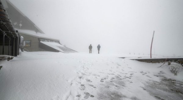epa10957160 People walk on an snow-covered area in Campo Imperatore, in the Gran Sasso massif, L'Aquila, Italy, 04 November 2023. The first snow of the season fell overnight.  EPA/EMANUELE VALERI