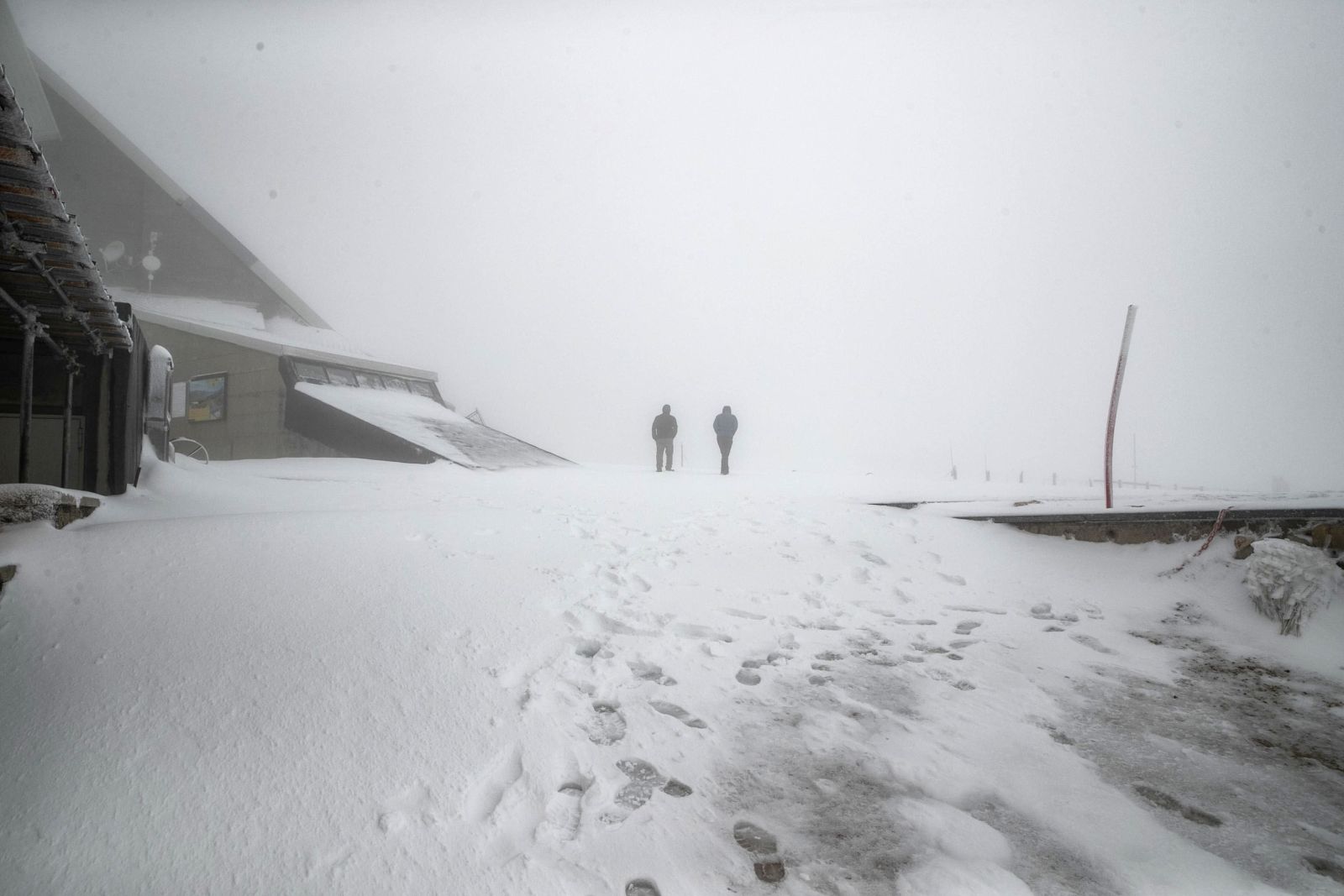 epa10957160 People walk on an snow-covered area in Campo Imperatore, in the Gran Sasso massif, L'Aquila, Italy, 04 November 2023. The first snow of the season fell overnight.  EPA/EMANUELE VALERI