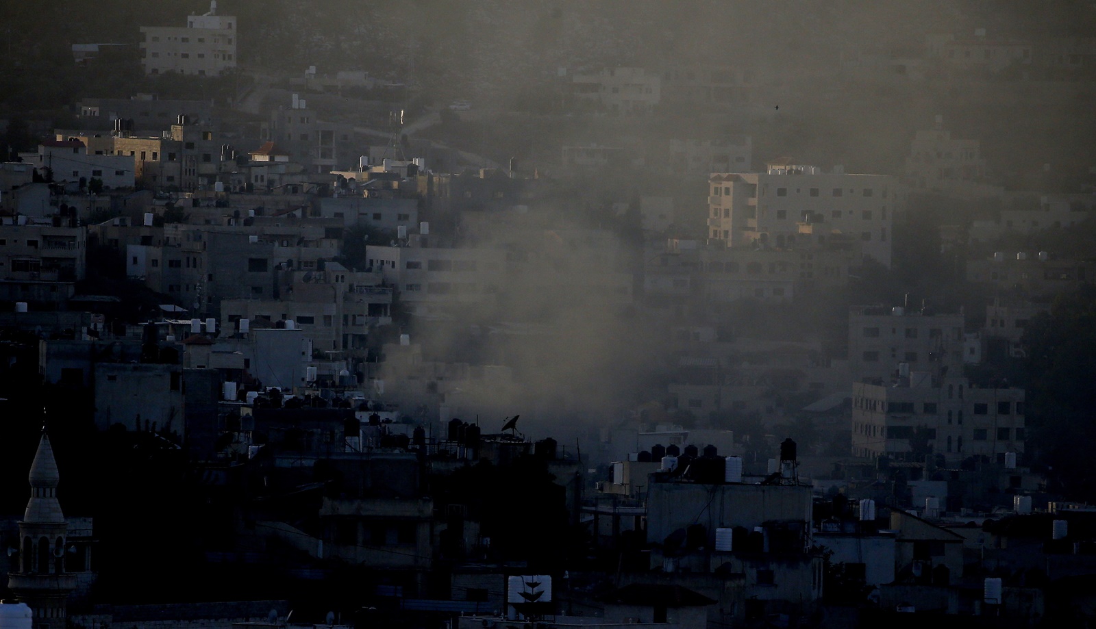 epa10966691 Smoke rises over Jenin during clashes between Palestinians and Israeli troops following an Israeli raid at the Jenin refugee camp, in the West Bank city of Jenin, 09 November 2023. According to the Palestinian Health Ministry, at least 13 Palestinians were killed and around 15 others were injured during heavy clashes with Israeli troops. Since 07 October 2023, more than 160 Palestinians have been killed, while over 2,000 have sustained injuries in the West Bank.  EPA/ALAA BADARNEH