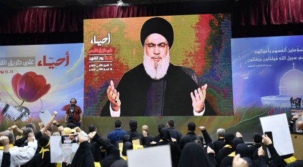 epa10970227 Hezbollah supporters raise their hands as they listen to a speech by Hezbollah leader Hassan Nasrallah, shown on a large screen, on the occasion of Hezbollah's annual 'Martyrs' Day', in the southern suburb of Beirut, Lebanon, 11 November 2023. In his speech, Hezbollah leader Hassan Nasrallah commented on the ongoing conflict between Israel and Hamas.  EPA/WAEL HAMZEH